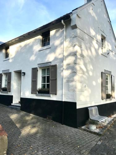 a white building with windows and a bench on a street at B&B No. 42 in Valkenburg