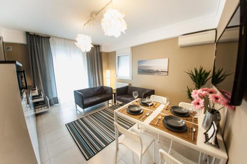 a kitchen and living room with a table and chairs at Peraia Club Apartments in Perea