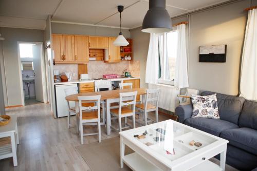 ein Wohnzimmer mit einem Sofa und einem Tisch in der Unterkunft Hestaland Riverside Cottage in Staðarhús