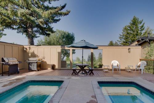 un patio trasero con piscina, mesa y sombrilla en Pioneer Condominiums en Bogus Basin