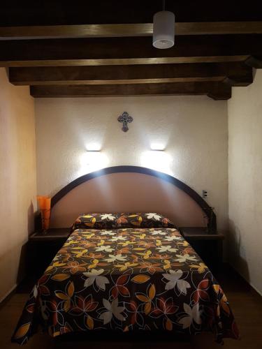 Hotel Barroco في بوبلا: غرفة نوم مع سرير مع لحاف متهالك