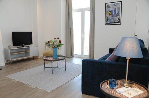 a living room with a blue couch and a tv at Lisbonne Appartements in Lisbon