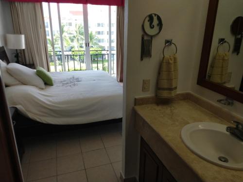 a bathroom with a bed and a sink and a tub at Apartamento Pelicanos, Nuevo Vallarta in Nuevo Vallarta