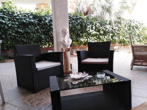 a group of chairs and a coffee table on a patio at Villa Royal Etna Stars in Zafferana Etnea