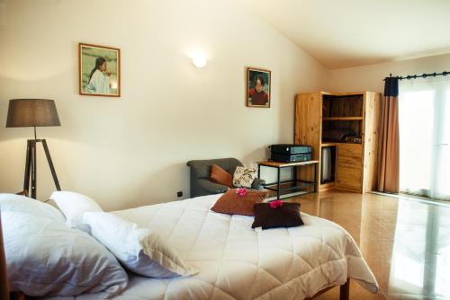 a bedroom with a bed and a living room at Somptua Garden in Ivato