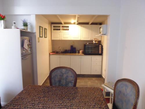 a kitchen with a table and chairs and a microwave at Tu Lugar en Buenos Aires in Buenos Aires