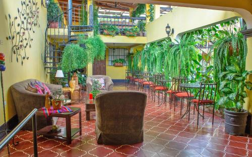 een kamer met tafels, stoelen en planten bij Hotel Las Camelias Inn by AHS in Antigua Guatemala