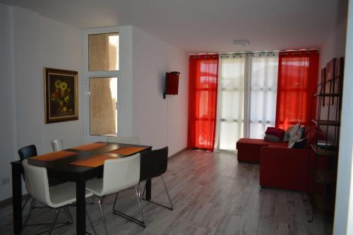 een woonkamer met een tafel en stoelen en een bank bij Family Beach Apartment in Playa de las Americas