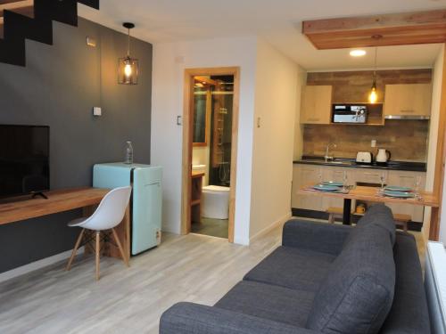 a living room with a couch and a kitchen at EcoLofts Croacia 1028 in Punta Arenas
