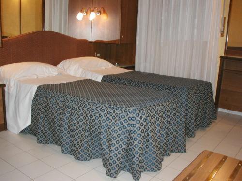 a bedroom with a bed with a blue and white blanket at Hotel Vienna in Milan