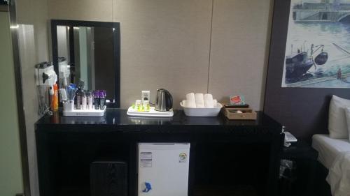 un mostrador en una habitación de hotel con nevera en Rampart Hotel, en Gwangmyeong
