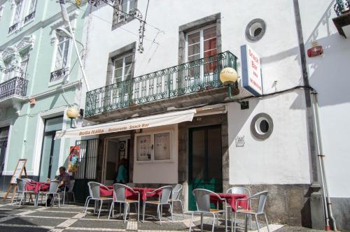 a group of chairs sitting outside of a building at Sao Jose Guesthouse in Ponta Delgada