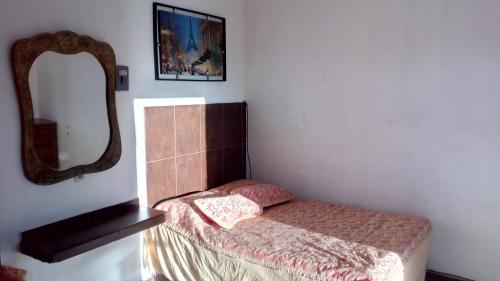 - une petite chambre avec un lit et un miroir dans l'établissement hotel quinta sierra, à San Blas