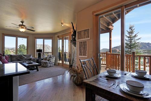 een woonkamer met een tafel en uitzicht op een terras bij Bighorn Mountain 19B Condo in Estes Park
