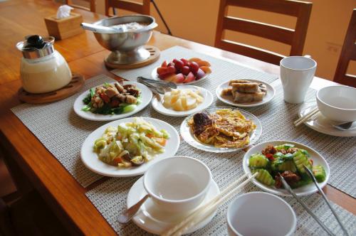 einen Tisch mit Teller mit Lebensmitteln darüber in der Unterkunft Shuang Liou B&B in Mingjian