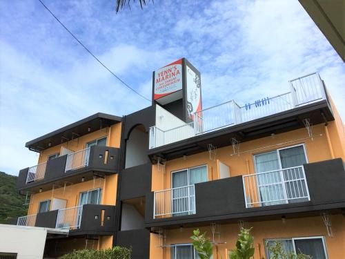 a hotel with a sign on top of it at Yenn's Marina Inn Zamami Condominium in Zamami