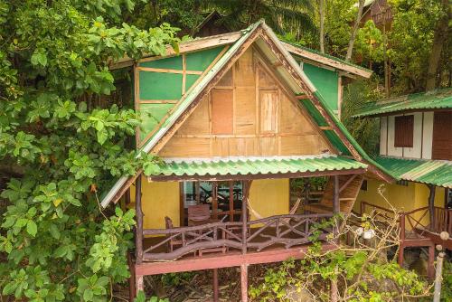 a small wooden house with a green roof at Mai Pen Rai Bungalows in Than Sadet Beach