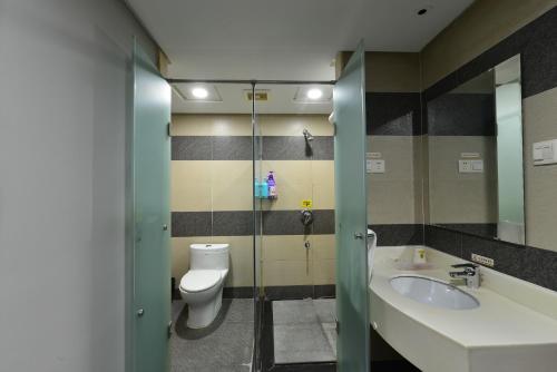 a bathroom with a toilet and a sink at Jihao Selected Hotel in Ningbo