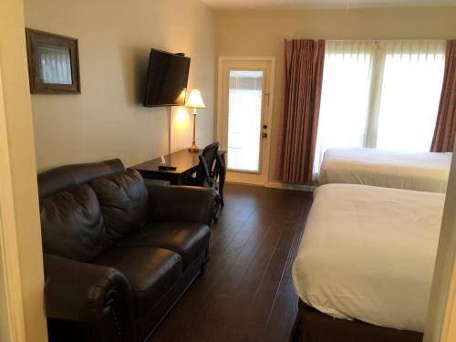 a hotel room with a couch and a bed at Mountain Star Lodge in Austin
