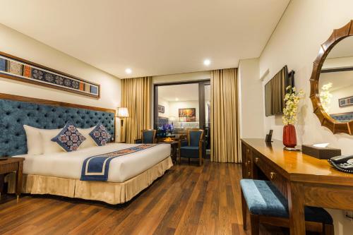 a hotel room with a bed and a desk at Balcona Hotel Da Nang in Da Nang