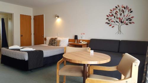 une chambre d'hôtel avec un lit, une table et un canapé dans l'établissement Aalton Motel, à Christchurch