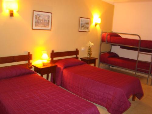 two beds in a room with two bunk beds at Residencia Santiago Mallorca in Cala Figuera