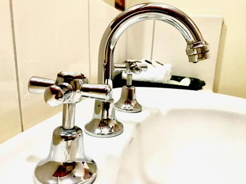 a bathroom sink with a chrome faucet at Broadford Sugarloaf Motel in Broadford