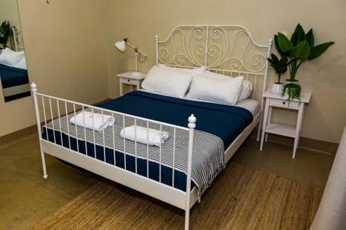 Coolangatta Sands Hotel في غولد كوست: غرفة نوم بسرير ابيض وملاءات زرقاء ومخدات بيضاء