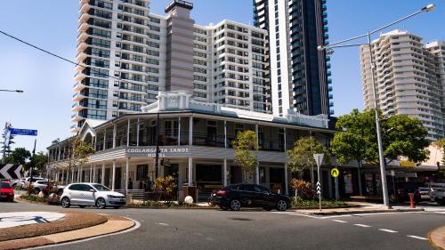 a building on a street with tall buildings at Coolangatta Sands Hotel in Gold Coast