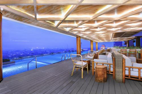 a deck with a table and chairs on top of a building at The Alts Hotel in Palembang