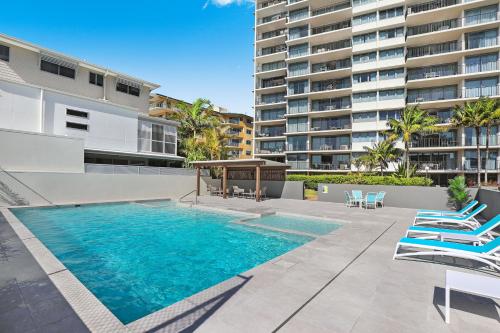 a large swimming pool in front of a large building at Majorca Isle Beachside Resort in Maroochydore