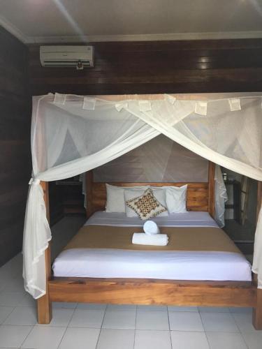 a large bed with a canopy in a room at Linda Beach Hotel in Nusa Lembongan