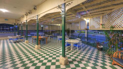 a restaurant with tables and chairs on a checkered floor at The Park Motel in Charters Towers