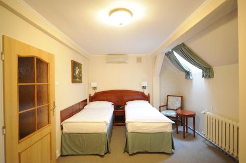 a hospital room with three beds and a window at Hotel Prince de Ligne in Teplice