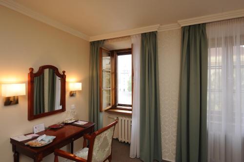 a hotel room with a desk and a window at Hotel Prince de Ligne in Teplice