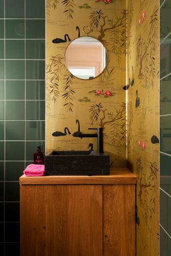 a bathroom with a black sink and green tiles at Rooftop 52, City-Apartment in Assen