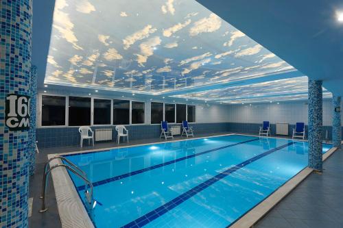 a large swimming pool with a ceiling with a mural of clouds at Hotel Pliska All inclusive in Golden Sands