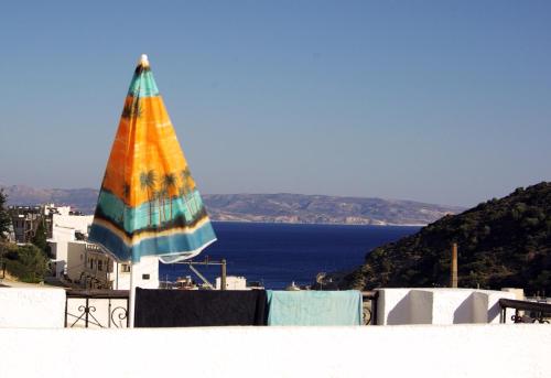 a colorful umbrella on top of a building with the ocean at Ostria in Agia Galini