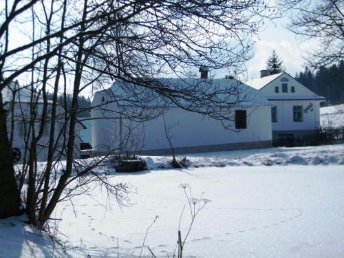 una casa bianca nella neve con un cortile di Rainmühle a Mariánské Lázně