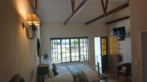 a bedroom with a bed and a large window at The Highveld Cape Inn in Pretoria