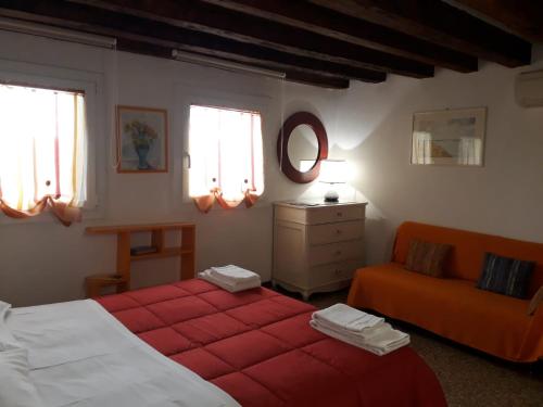 a bedroom with two beds and a orange couch at Cà Del Giazzo in Venice