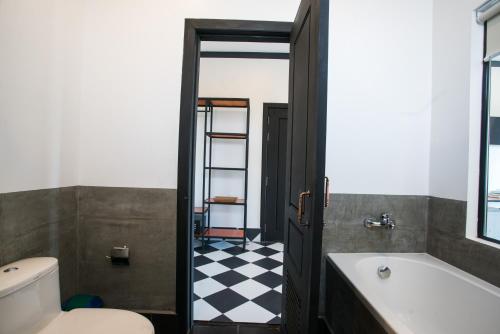a bathroom with a black and white checkered floor at Noni Tree Hostel in Siem Reap