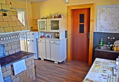 Una cocina con un refrigerador blanco y un fregadero. en Chata u Borysa, en Białowieża