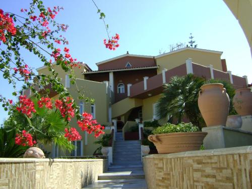 a house with flowers and plants in front of it at Heaven Apartments in Agia Marina Nea Kydonias