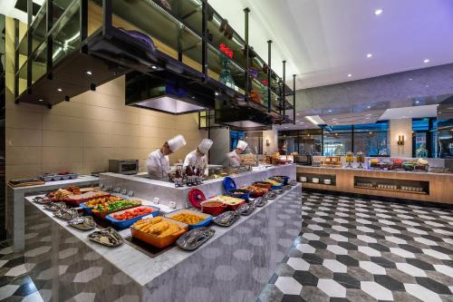 two chefs preparing food in a restaurant kitchen at Novotel Suites Shanghai Hongqiao in Shanghai