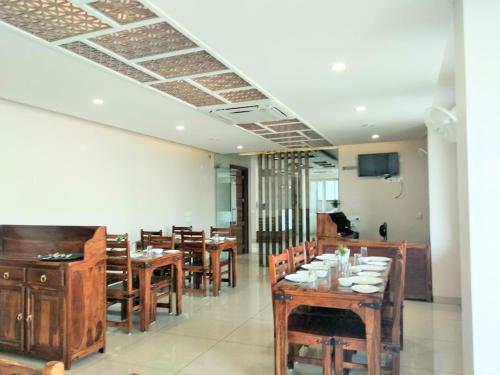 a dining room with wooden tables and chairs at Hotel The Lighthouse in Jaipur