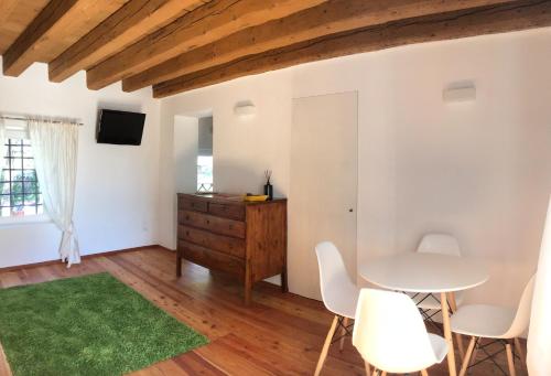 una sala de estar con paredes blancas y techo de madera. en La Foresteria di Villa Gorgo, en San Vito al Torre