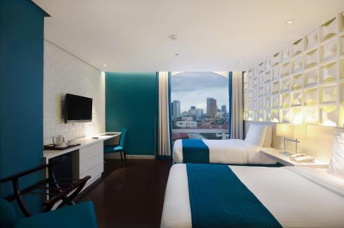 een hotelkamer met een groot bed en een raam bij The Bayleaf Intramuros in Manilla