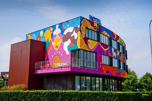 een gebouw met een schilderij van een koe erop bij Hotel ten Cate Emmen in Emmen