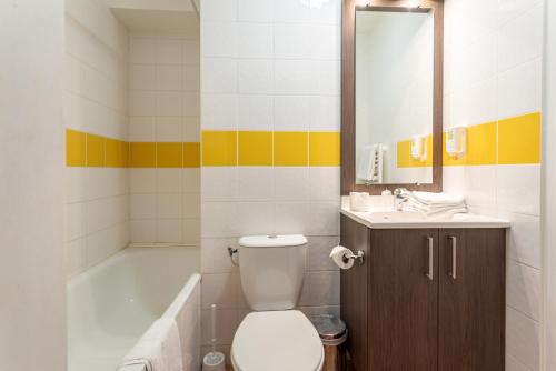 a bathroom with a toilet and a sink and a tub at Zenitude Hôtel-Résidences Nîmes Centre in Nîmes